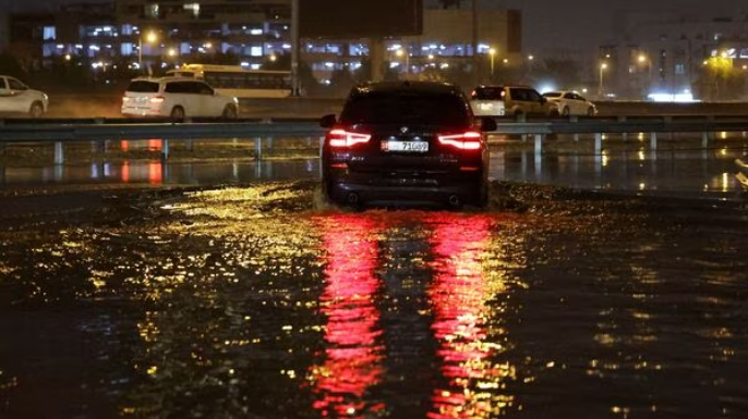 A car navigates flooded streets after a heavy rainstorm