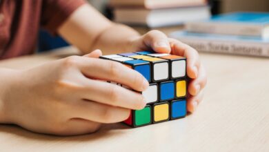 “Person solving Rubik’s Cube to improve memory, focus, and problem-solving skills – educational toy available at sandhai.ae.”